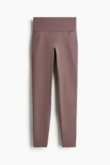 Leggings deportivas de talle alto y cintura ancha, color marrón, confeccionadas en tejido funcional con bolsillos abiertos en los laterales.