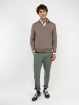 Sweater de punto color verde militar con cuello alto y medio cierre frontal de cremallera, manga larga y detalles acanalados en los puños y el dobladillo.