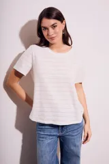 Remera blanca de manga corta con cuello redondo y textura de líneas horizontales con perforaciones.