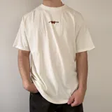 Remera blanca de corte regular, con estampa en la espalda que presenta la leyenda "VCP COLLECTION EVERYDAY MOOD" junto a un gráfico de fresas.