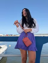 Bandolera pequeña y compacta tipo porta celular, confeccionada en cuero sintético color terracota. Cuenta con correa larga ajustable, cierre principal y bolsillo frontal con tapa y broche metálico.