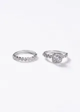 Set de dos anillos de plata 925. El primero es un anillo estilo Lady Di con una zirconia central cuadrada rodeada de pequeñas piedras y banda decorada. El segundo es un anillo tipo sin fin con engaste de pequeñas zirconias en toda la mitad superior.