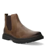 Bota tipo Chelsea de cuero color marrón, con paneles elásticos laterales en color marrón oscuro y suela de goma dentada negra.