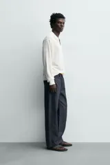 Jeans de corte recto en denim azul oscuro, con mezcla de algodón y cáñamo sin lavados. Presenta diseño de cinco bolsillos, tiro medio y cierre frontal con cremallera y botón.