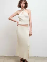 Top de punto acanalado color negro, con diseño de cuello halter y abertura frontal tipo gota.