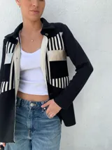 Camisa de tejido de punto en algodón con apliques en cuero, de corte recto y manga larga. Diseño con bloques de color negro, blanco y dorado.