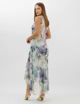 Conjunto compuesto por un vestido midi de gasa con estampado floral en tonos violeta, azul y crema, con escote en V, tirantes anchos y ruedo asimétrico con volados. Incluye una chaqueta corta tipo torera de mangas 3/4 confeccionada en la misma tela. Posee forro interno a tono.