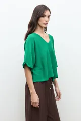 Sweater oversized de punto color verde, con escote en V y mangas cortas holgadas.