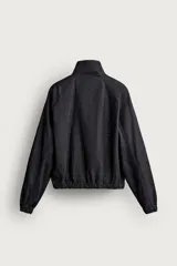 Sudadera de corte relajado confeccionada en denim de algodón con efecto lavado. Presenta cuello subido con cierre frontal de cremallera, manga larga con puños elásticos y bajo elástico. Incluye un bolsillo con cierre de cremallera en el pecho.
