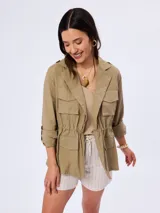Campera cazadora de estilo safari color verde militar, con múltiples bolsillos con solapa en el frente, cuello solapa y cordón ajustable en la cintura.