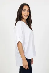 Blusa blanca de corte relajado, con escote en V y mangas largas con sistema de ajuste mediante trabilla y botón para llevarlas arremangadas. Confeccionada en tejido de viscosa con caída fluida y ruedo redondeado.
