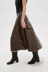 Falda midi de corte acampanado confeccionada en eco-cuero color marrón oscuro, con diseño de paneles y cintura alta.