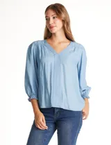 Blusa Zac & Rachel de lyocell color azul, con escote en V y panel central con pespuntes. Presenta mangas tres cuartos abullonadas con frunces en los hombros y puños elastizados con detalle de volante.