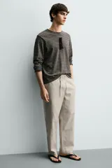Pantalón de corte regular fit confeccionado en tejido mezcla de algodón, con cintura elástica ajustable mediante cordón, bolsillos laterales y bolsillos traseros de vivo.