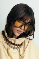 Lentes de sol con armazón de policarbonato con estampado carey y cristales amarillos. Diseño de estilo aviador con puente superior recto.
