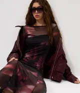 Vestido midi de tul con transparencia y estampado de efecto manchado. Presenta un diseño ajustado con mangas largas y recortes en la falda que aportan movimiento.