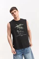 Musculosa oversize blanca de algodón, con sisas amplias y estampa frontal de inspiración tropical con palmeras y texto.