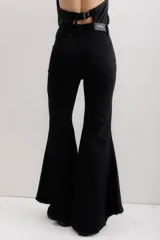 Jean elastizado azul oscuro con diseño de volados en la parte baja de la pierna, ruedo descosido con juego de largos (más largo atrás que adelante).