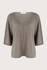 Suéter de punto color gris con cuello en V, manga tres cuartos y detalle de costura central vertical. Presenta un diseño de silueta holgada y terminaciones acanaladas en puños y ruedo.