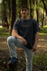 Remera gris de manga corta raglán con costuras a la vista y calce relajado.