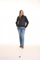 Campera combinada Current Air, con torso acolchado en diseño de rombos y mangas de tejido de punto grueso con diseño de ochos. Presenta cierre frontal metálico, cuello alto y puños y ruedo acanalados.