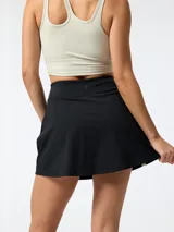 Skort deportivo negro con short interior integrado, cintura alta y franjas verticales blancas en los laterales. Confeccionado con tecnología Aloe Vera.