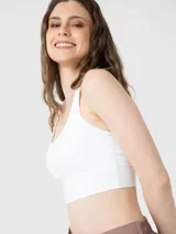 Top deportivo blanco de sujeción media con espalda cruzada, confeccionado con tecnología Aloe Vera para una textura suave y elástica.