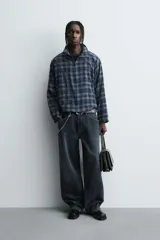 Camisa boxy fit de cuadros en tonos azules y negros, confeccionada en tejido con mezcla de algodón. Cuenta con cuello solapa, manga larga y cierre frontal con cremallera.