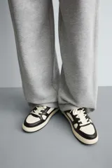 Zapatillas urbanas de cuero sintético color negro y blanco, con cordones y suela chunky color crema.