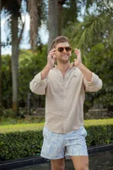 Camisa de manga larga color beige con estampado floral celeste en short.