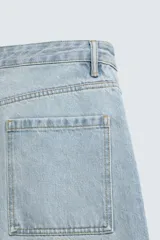 Jeans de hombre color azul claro con efecto lavado, de corte relajado desde la cadera que se estrecha ligeramente en el bajo. Tienen tiro medio, cinco bolsillos y cierre frontal con cremallera y botón.