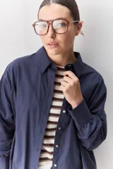 Camisa celeste de corte oversize, con mangas largas, cuello camisero y cierre frontal de botones.