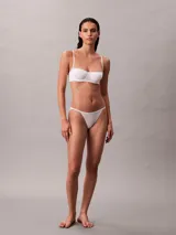 Sujetador tipo balconette Calvin Klein de la línea Cotton Modal Bare, color blanco. Presenta copas suaves sin relleno, aros flexibles para mayor sujeción, tirantes ajustables y cierre de gancho en la parte trasera. Incluye un pequeño parche con el logo de la marca en el centro.