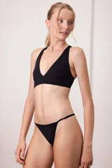 Top de bikini negro con escote en V profundo y tirantes anchos que se cruzan en la espalda.