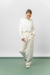 Pantalón deportivo de corte wide leg con caída relajada. Presenta cintura elastizada con cordón ajustable, bolsillos laterales y un interior frizado para mayor abrigo.