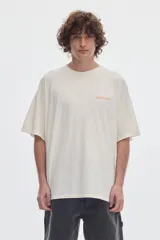 Remera boxy fit de cuello redondo y manga corta, confeccionada en algodón con lavado desgastado (washed). Cuenta con pequeña estampa tipográfica en el pecho con la palabra "PASTICHE" en color naranja.