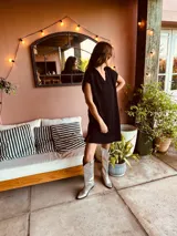 Minivestido negro tejido en lurex metálico con cuello en V y mangas cortas.