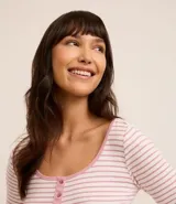 Conjunto de pijama largo de punto, compuesto por una blusa de manga larga con botones decorativos y un pantalón con cintura elástica y puños ajustados.