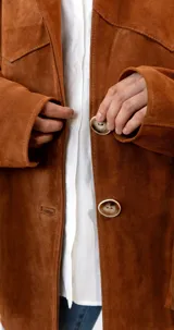 Blazer marrón de gamuza con flecos en la espalda y mangas largas.
