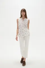 Musculosa de poliéster color blanco, con cuello en V y diseño holgado sin mangas.