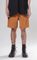 Bermuda de corte regular color tabaco, confeccionada en tejido de algodón con textura tipo lino. Presenta cintura elástica con cordón ajustable con detalle de marca bordada y dos bolsillos delanteros.