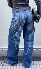 Jean de corte recto y tiro medio, color azul lavado con estampado de alas en tono más claro que recorre la parte trasera y los laterales de las piernas.