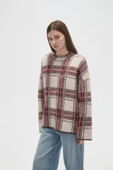Sweater de punto jacquard con diseño a cuadros en tonos beige y bordó, de corte holgado, cuello redondo y mangas largas.
