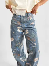 Jean wide leg de tiro alto con estampado de flores y hojas verdes, de corte amplio y cómodo.