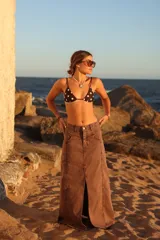 Falda larga de jean color bordó gastado, con corte central y diseño de cinco bolsillos.