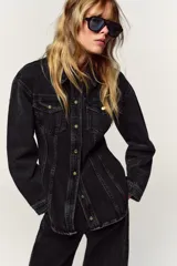 Camisa de denim color negro gastado, corte entallado, cuello solapa, manga larga, bolsillos delanteros con solapa y cierre frontal con botones dorados.