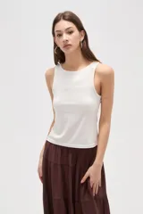 Musculosa de corte al cuerpo con cuello redondo y diseño sin mangas, confeccionada en tejido liso.