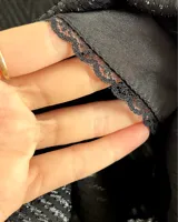 Pantalones negros de pierna ancha con diseño geométrico en lúrex plateado. Tiro medio con detalle de tableados en el frente.