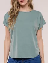 Remera de silueta amplia y relajada confeccionada en algodón y poliéster, de color verde, con escote a la base y mangas cortas de hombro caído. Presenta dobladillo enrollado y ruedo curvo.