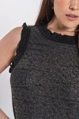 Vestido largo de tejido de punto con brillo, color negro con sutiles hilos metalizados, sin mangas, con cuello alto y aberturas laterales.